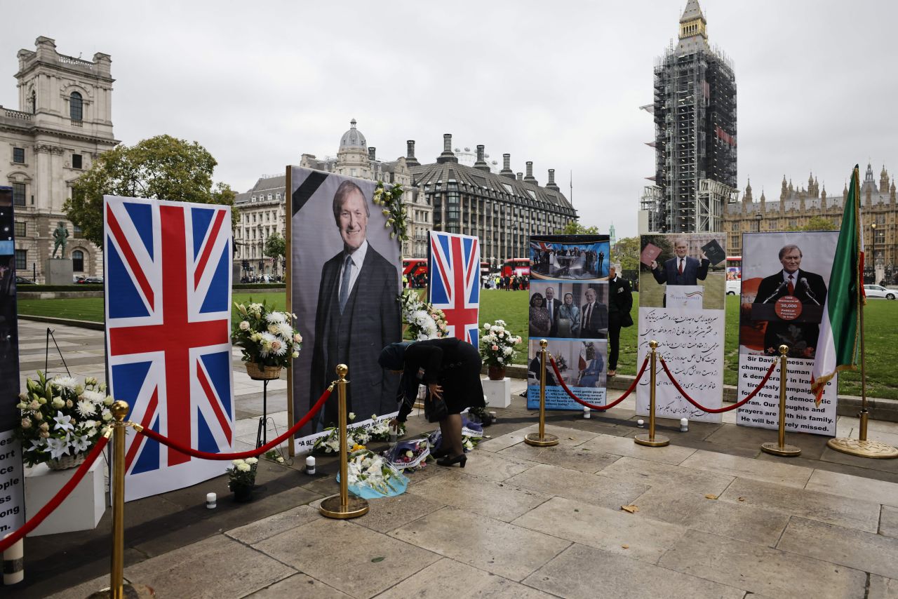 A person places a candle during a memorial service to pay tribute to slain British lawmaker <a href="https://www.cnn.com/2021/10/15/uk/uk-mp-stabbed-intl-gbr/index.html" target="_blank">David Amess</a> in Parliament Square in London on Monday, October 18. Amess, a member of Prime Minister Boris Johnson's ruling Conservative Party, died after being stabbed several times at a constituency meeting east of London on Friday, October 15.