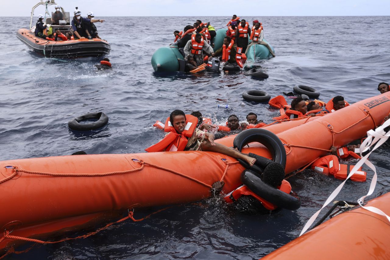 Migrants struggle to stay afloat before being rescued about 35 miles off the coast of Libya on Monday, October 18.