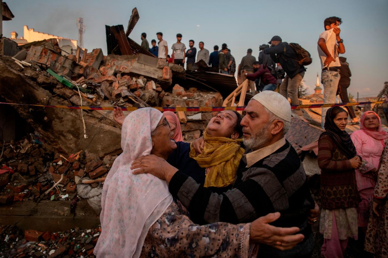 Villagers gather near the debris of a house destroyed in a gunfight in Pampore, Kashmir, on Saturday, October 16. Suspected militants have killed 11 civilians, including five migrant workers, in Kashmir <a href="https://www.cnn.com/2021/10/19/india/kashmir-india-migrant-workers-flee-intl-hnk/index.html" target="_blank">since early October</a> despite a widespread security crackdown in the heavily militarized region.