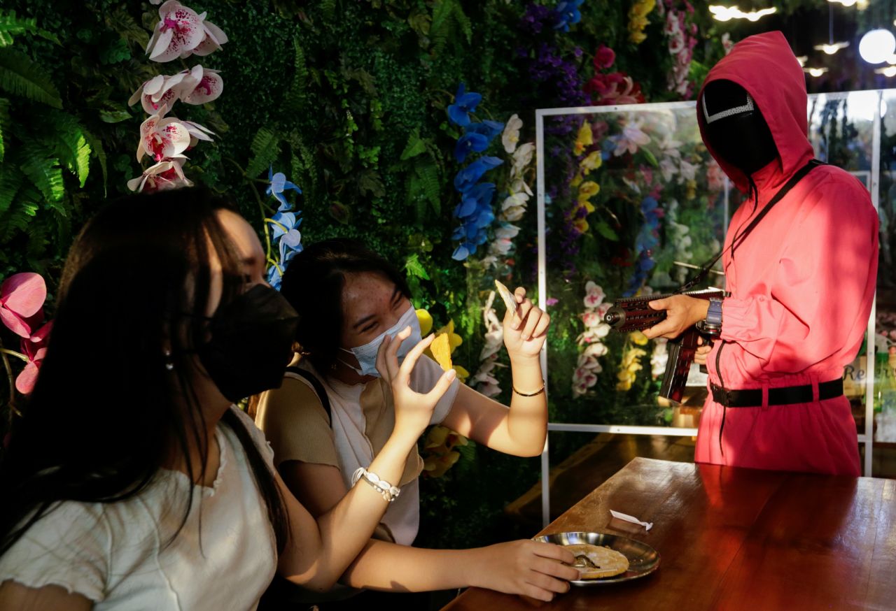 Customers play the honeycomb toffee game from the show "Squid Game" in Jakarta, Indonesia, on Friday, October 15. The fictional drama from South Korea is Netflix's "biggest-ever series at launch," the streaming company <a href="https://www.cnn.com/2021/10/12/media/squid-game-netflix-viewership/index.html" target="_blank">told CNN</a>.