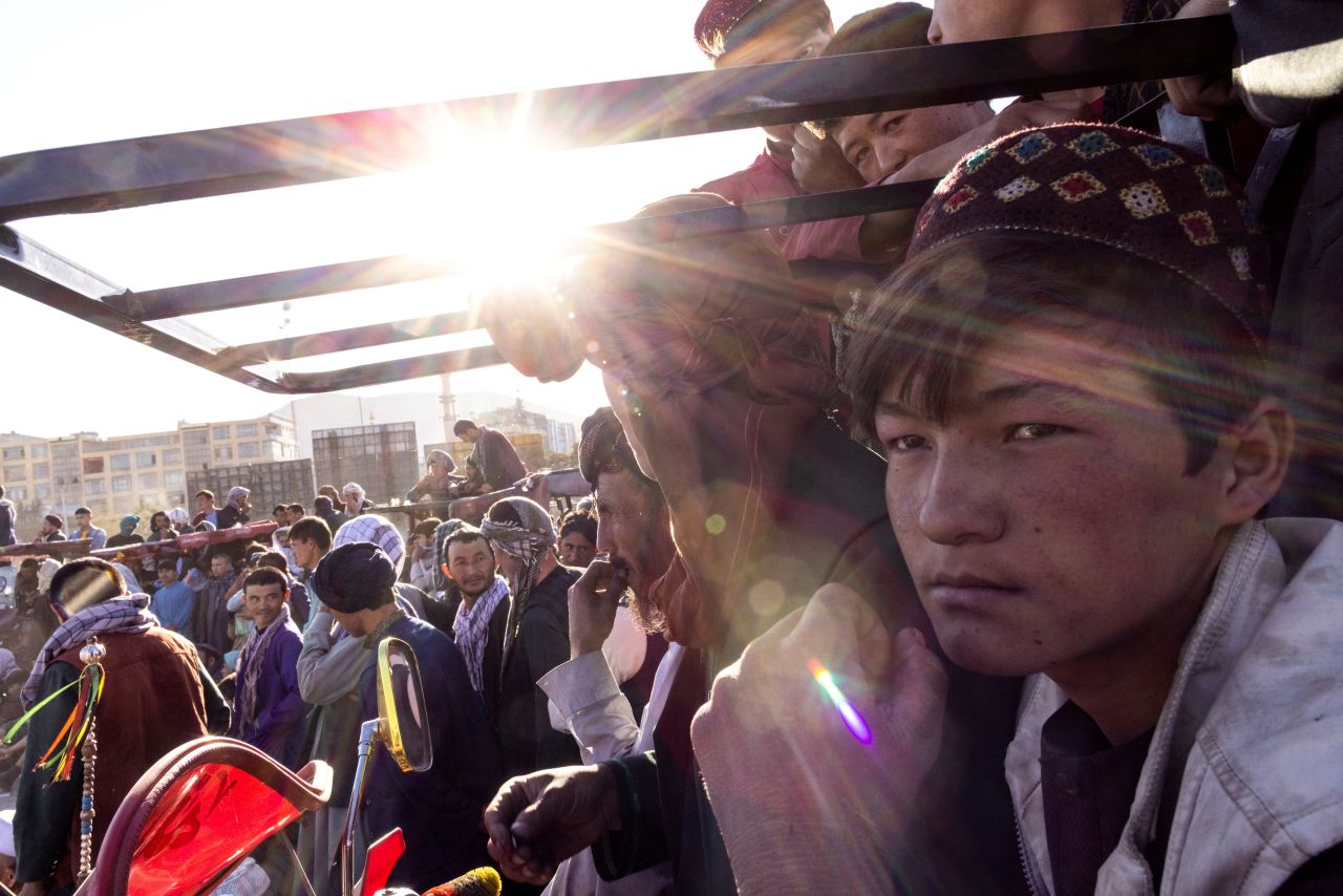 A crowd gathers around a makeshift wrestling arena at a cricket field in Kabul, Afghanistan, on Friday, October 15.