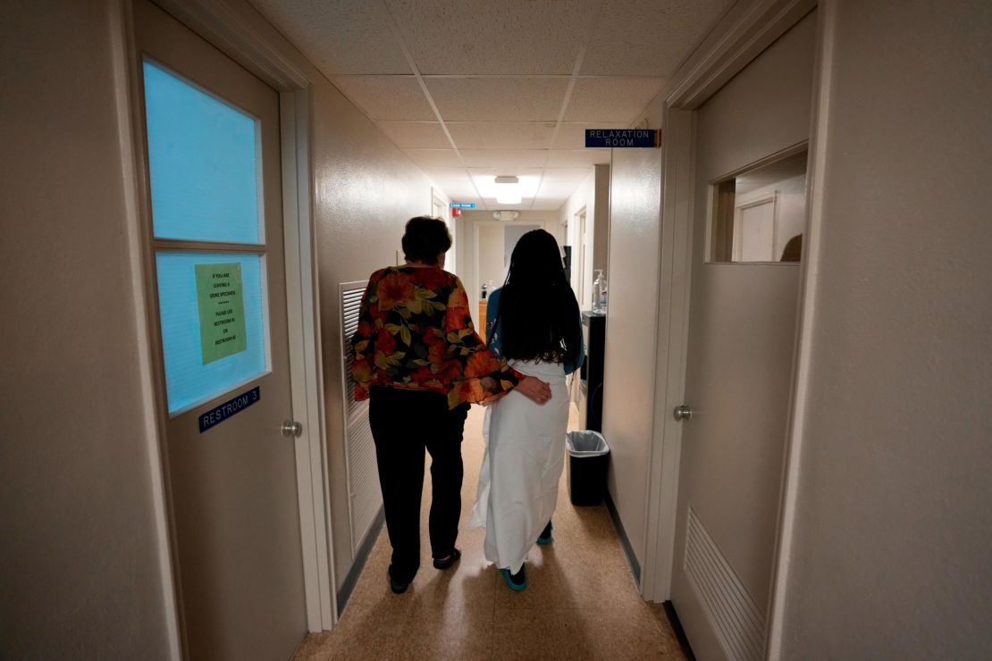 A 33-year-old mother of three from central Texas is escorted down the hall by a clinic administrator prior to getting an abortion on October 9 at Hope Medical Group for Women in Shreveport, Louisiana.