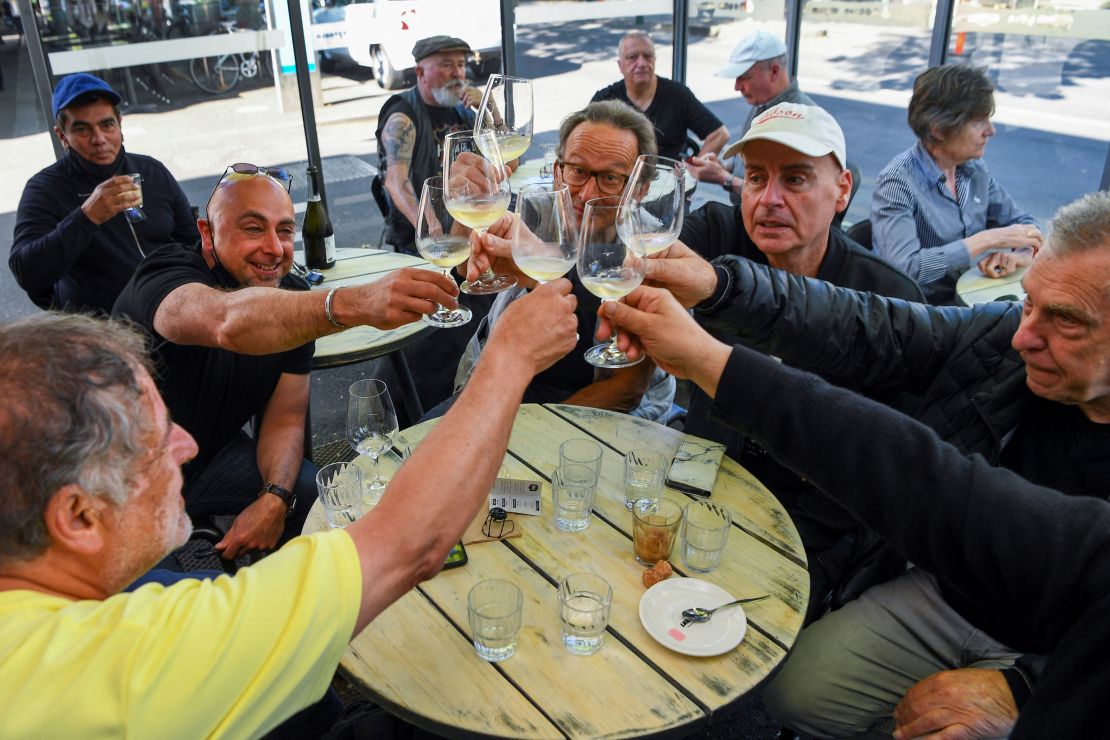 People enjoy a drink at a busy Lygon Street cafe in Melbourne on October 22, following the midnight lifting of coronavirus restrictions in one of the world's most locked-down cities.