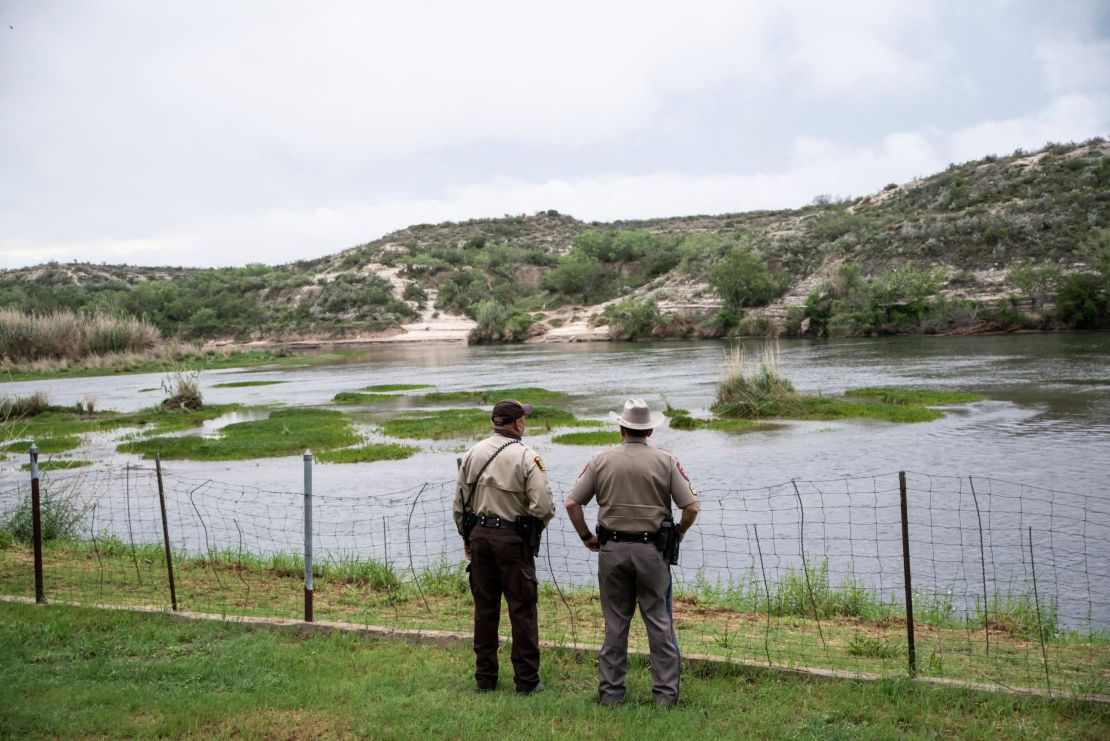 A pair of officers look out at the Rio Grande between Mexico and the United States in Del Rio, Texas this Spring.