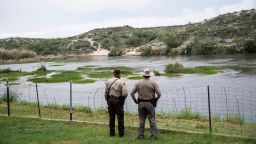A pair of officers look out at the Rio Grande between Mexico and the United States in Del Rio, Texas on May 16, 2021. 