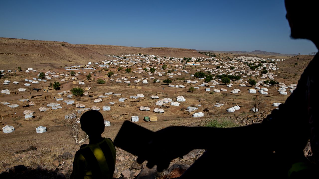 A Tigrayan man looks for cellular phone service on a mountain overlooking Um Rakuba refugee camp in eastern Sudan in January.