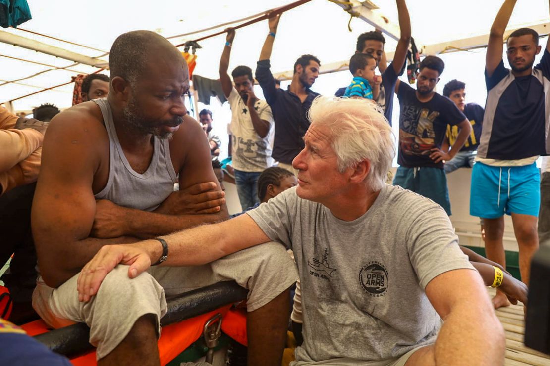 Actor Richard Gere, right, talks with migrants aboard the Open Arms Spanish humanitarian boat as it cruises in the Mediterranean Sea, Friday, Aug. 9, 2019. 