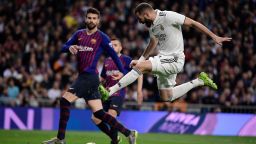 Real Madrid's French forward Karim Benzema (R) advances with the ball past Barcelona's Spanish defender Gerard Pique during the Spanish league football match between Real Madrid CF and FC Barcelona at the Santiago Bernabeu stadium in Madrid on March 2, 2019. (Photo by JAVIER SORIANO / AFP)        (Photo credit should read JAVIER SORIANO/AFP via Getty Images)