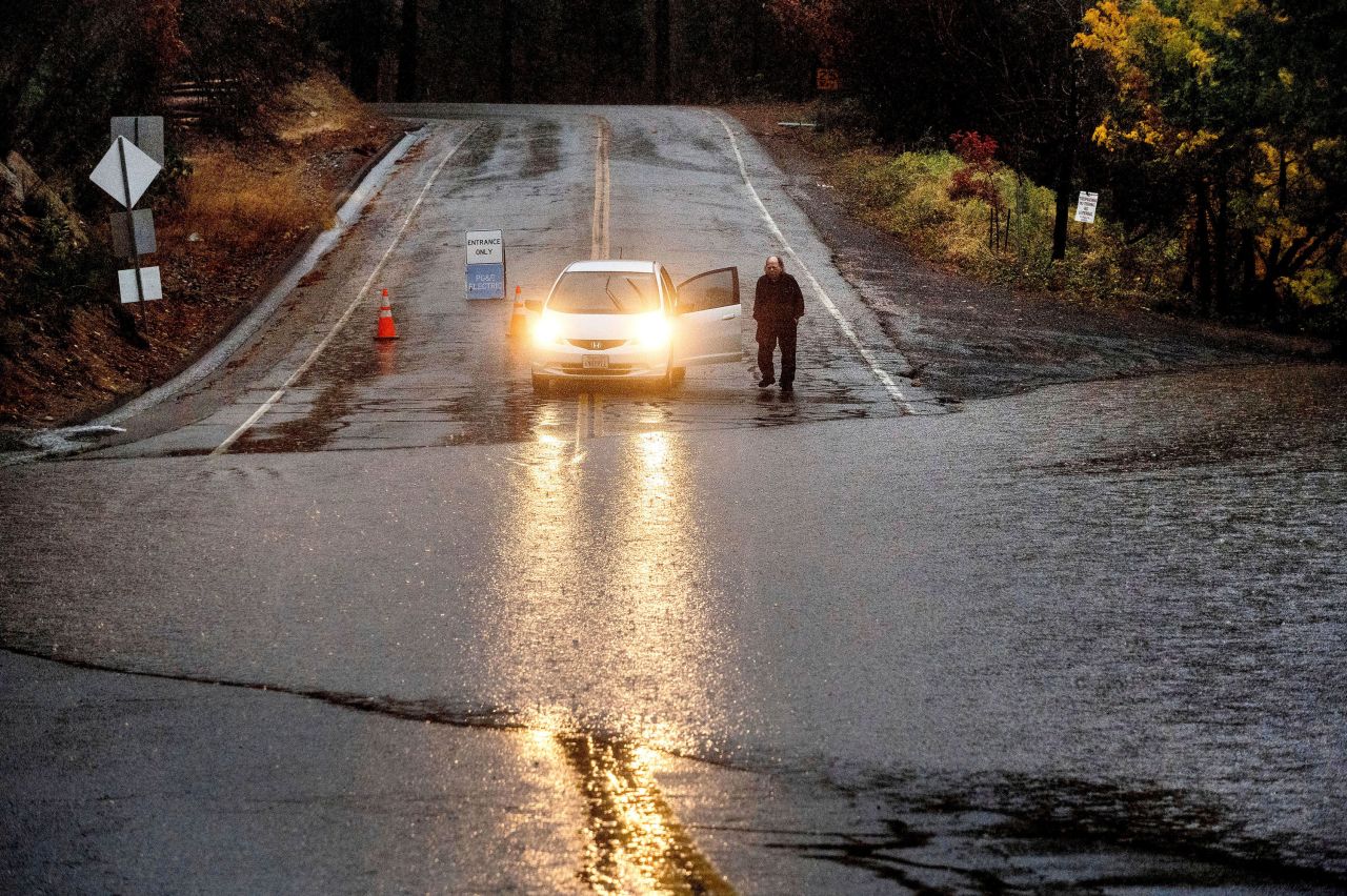 A motorist surveys floodwaters from Lake Madrone crossing Oro Quincy Highway in Butte County, California.