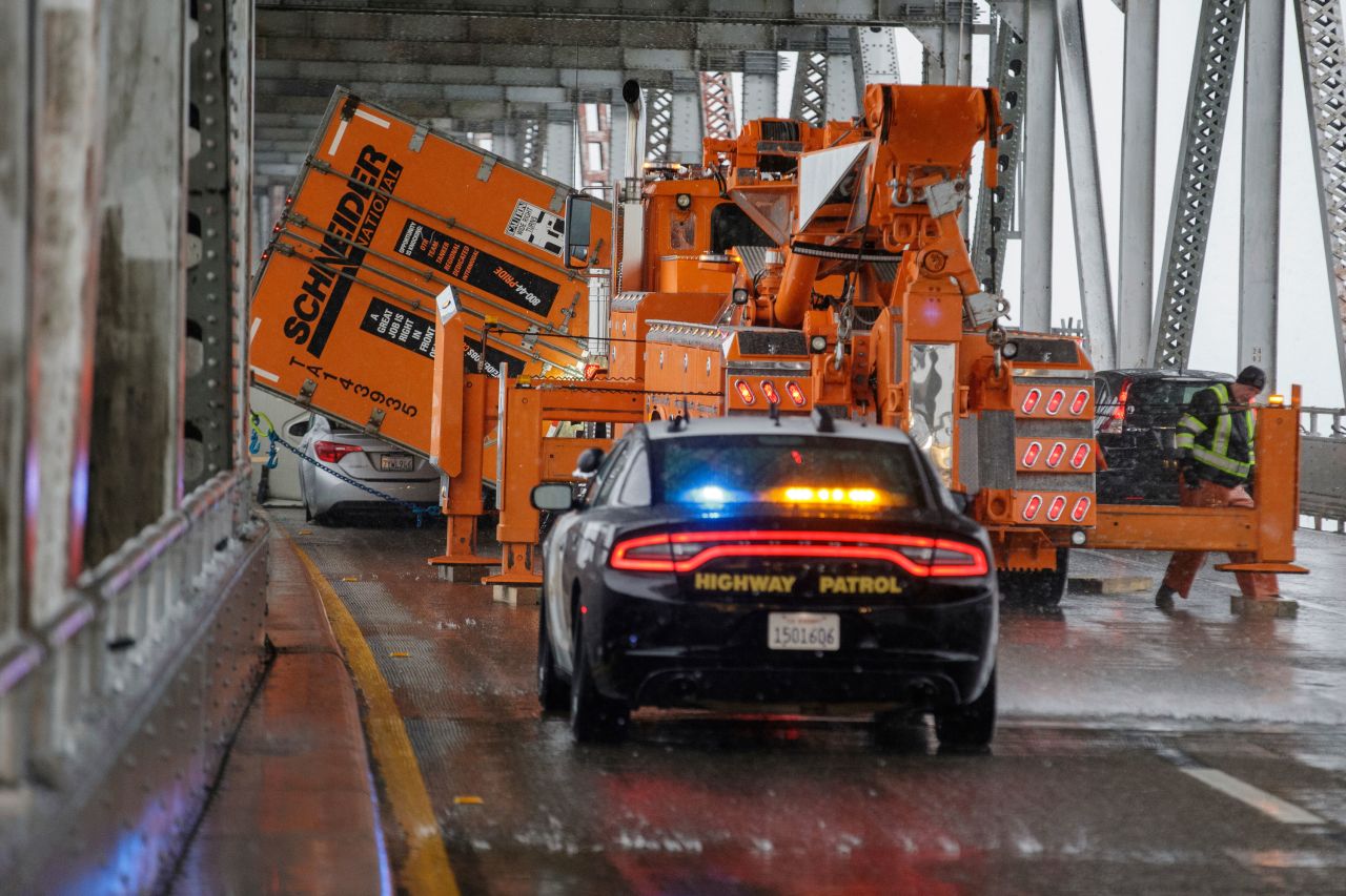 Crews work to upright an overturned tractor-trailer on the Richmond-San Rafael Bridge in Richmond, California.