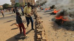 Sudanese protesters burn tyres to block a road in 60th Street in the capital Khartoum, to denounce overnight detentions by the army of members of Sudan's government, on October 25, 2021.