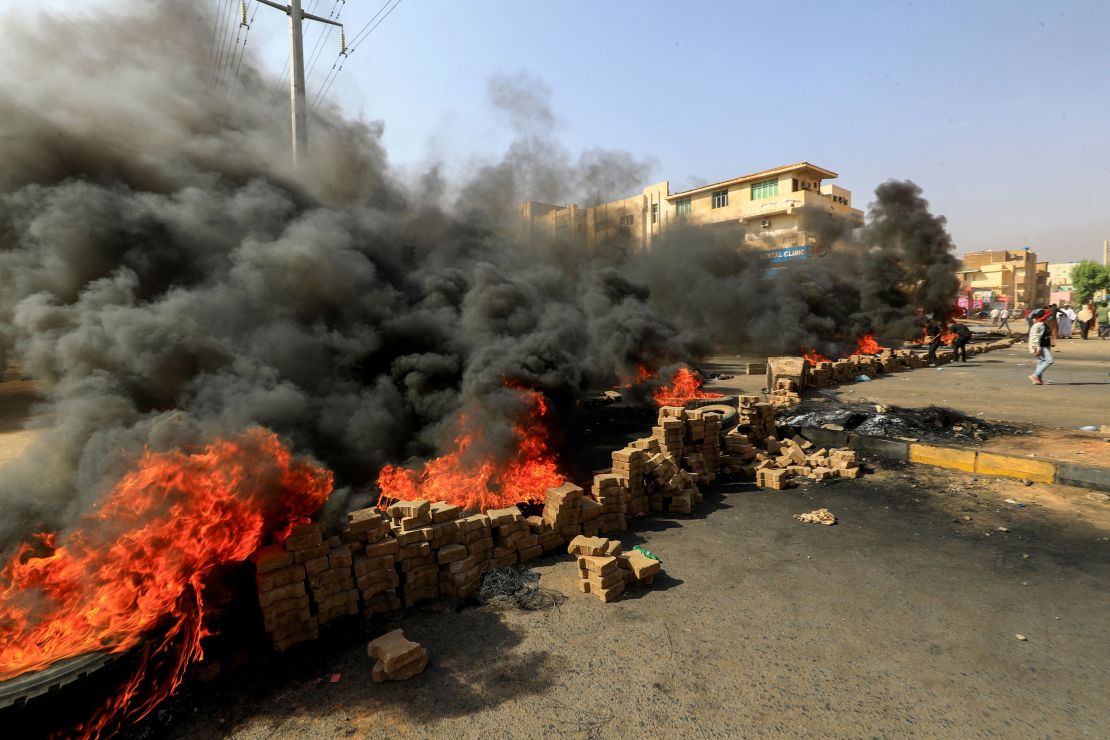 Sudanese protesters use bricks and burn tires to block 60th Street in the country's capital, Khartoum, on Monday.