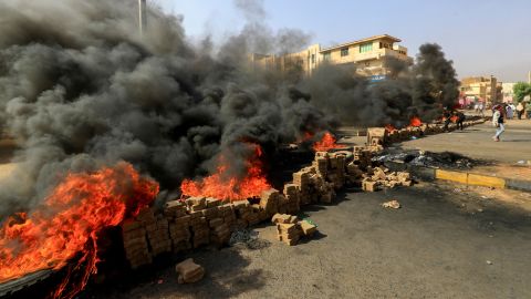 Sudanese protesters use bricks and burn tires to block 60th Street in the country's capital, Khartoum, on Monday.