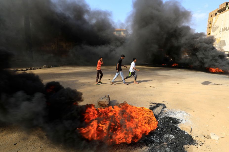 Protesters burn tires to block a road in Khartoum on October 25.