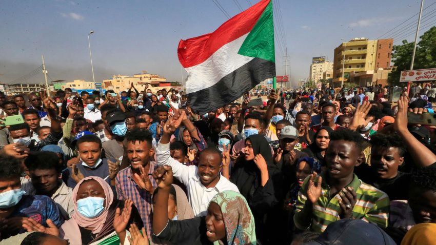 TOPSHOT - Sudanese protesters lift national flags as they rally on 60th Street in the capital Khartoum, to denounce overnight detentions by the army of government members, on October 25, 2021. - Armed forces detained Sudan's Prime Minister over his refusal to support their "coup", the information ministry said, after weeks of tensions between military and civilian figures who shared power since the ouster of autocrat Omar al-Bashir. (Photo by AFP) (Photo by -/AFP via Getty Images)