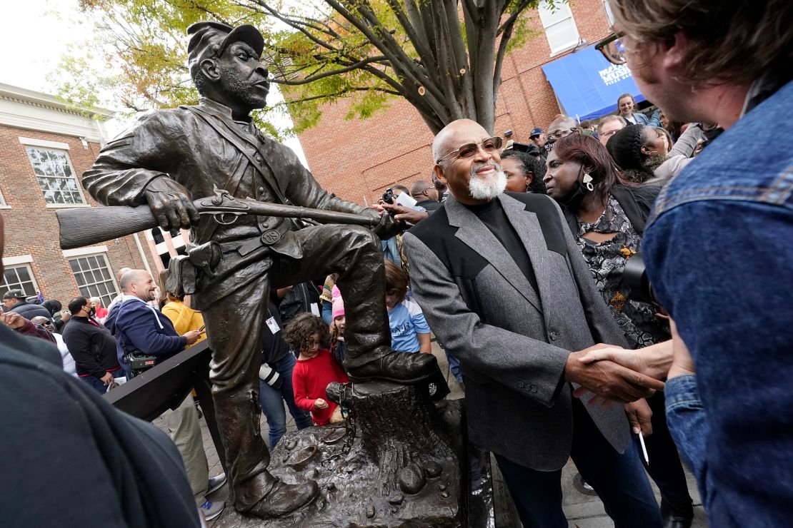 Sculptor Joe Howard shakes hands with people who came to see the unveiling of his statue honoring Black men who enlisted in the US Colored Troops.