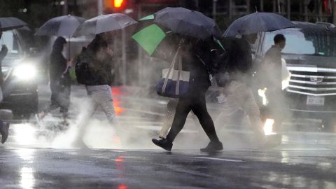 People with umbrellas walk in the rain and steam in New York's Manhattan borough on Tuesday.