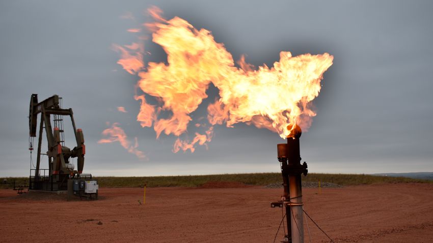 A flare burns natural gas at an oil well on Aug. 26, 2021, in Watford City, N.D.