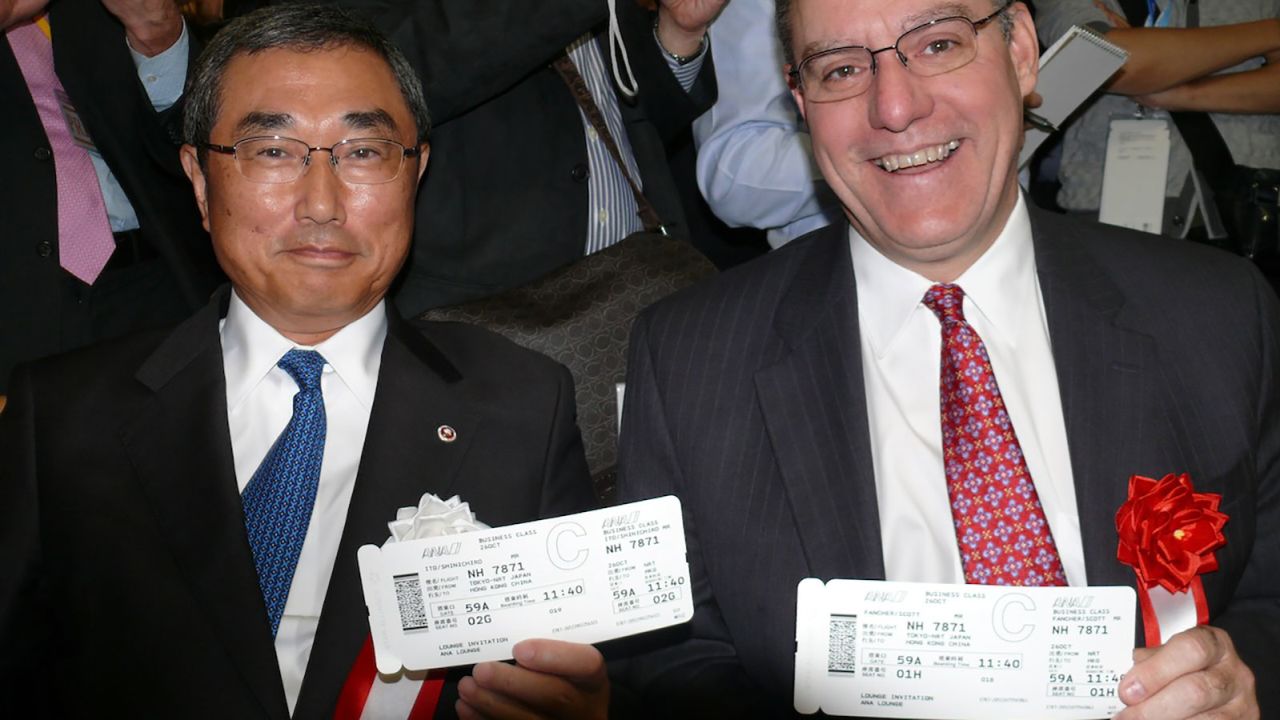 ANA's Shinichiro Ito and Boeing's Scott Faucher with their boarding passes for the inaugural flight.