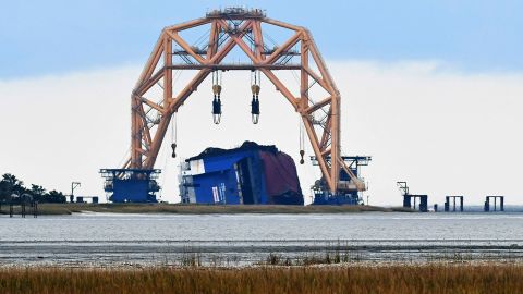 The Golden Ray wreck is seen on its side under a heavy-lift-twin-gantry catamaran near the St. Simons Island Pier. 