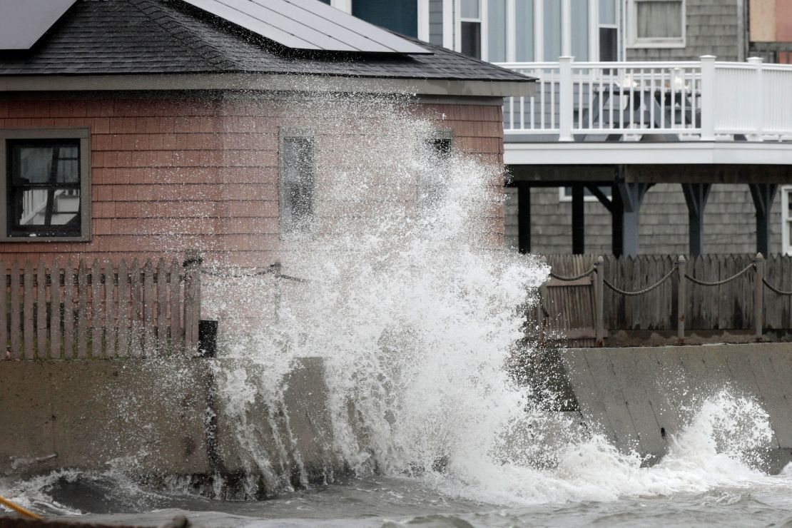 A wave crashes Tuesday into the retaining wall of a home in Fairhaven, Massachusetts.