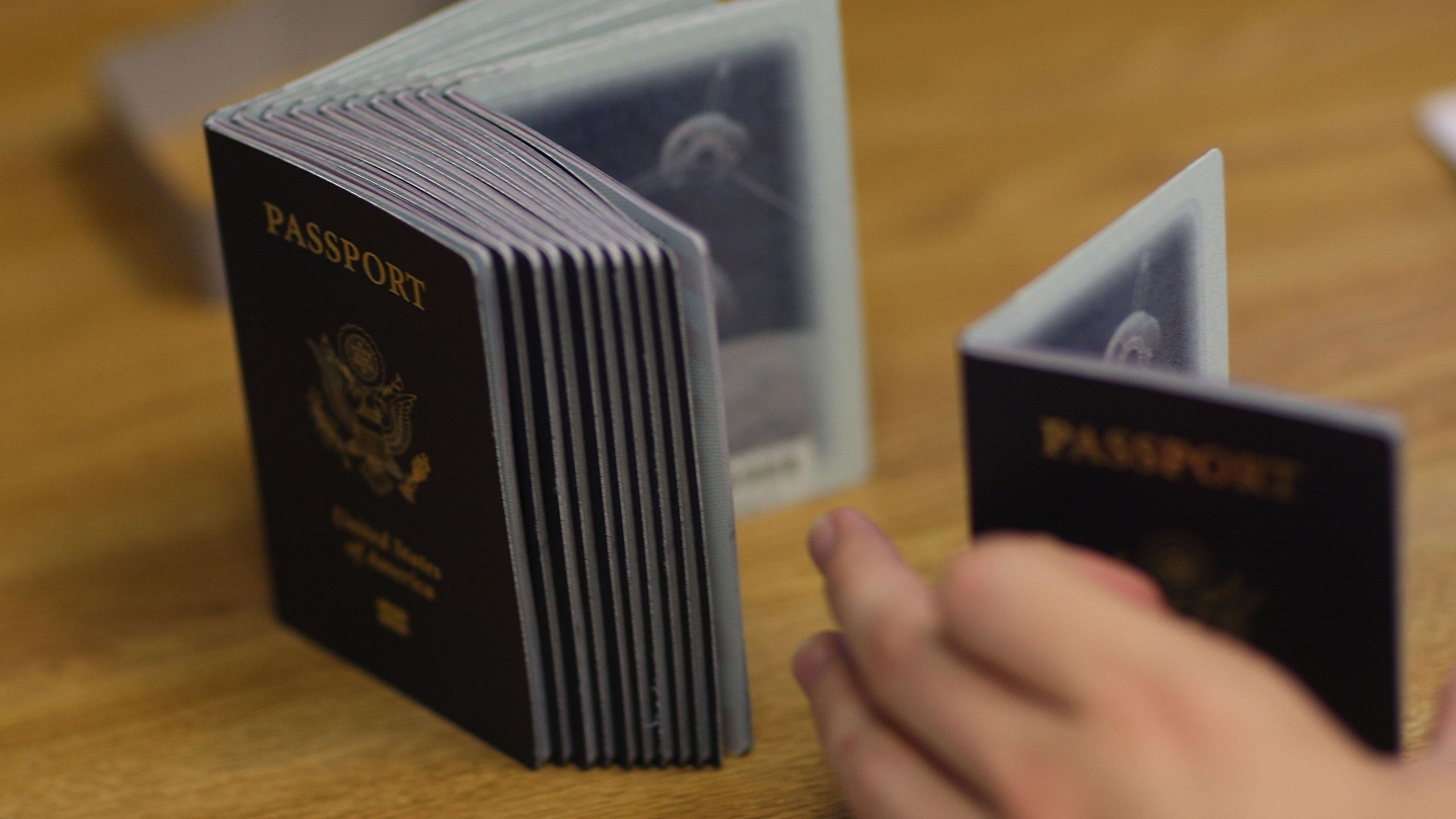 Un trabajador de procesamiento de pasaportes utiliza una pila de pasaportes en blanco para imprimir un nuevo pasaporte en la Oficina de Pasaportes de Miami el 22 de junio de 2007 en Miami, Florida.