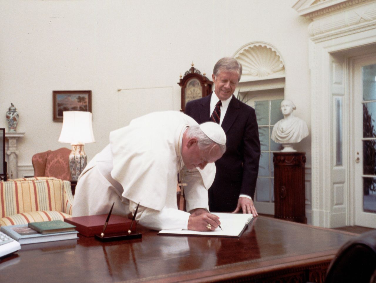 President Jimmy Carter watches Pope John Paul II sign the White House guest book in 1979. He was the first Pope to visit the White House.