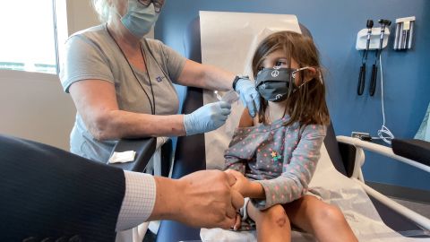 Bridgette Melo, 5, holds onto her dad, Jim Melo, as she gets the first of two Pfizer-BioNTech Covid vaccinations during a kids' clinical trial at Duke Health, September 28.