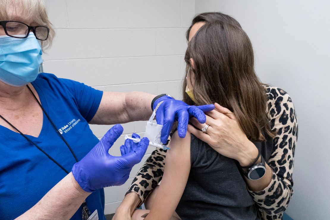 Alejandra Gerardo, 9, is held by her mom, Dr. Susanna Naggie, as she gets the second of two Pfizer-BioNTech Covid-19 vaccinations during a clinical trial for children at Duke Health.