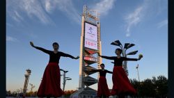Dancers perform in front of the countdown clock showing 100 days until the opening of the 2022 Beijing Winter Olympics, at the Olympic Park in Beijing on October 27, 2021. (Photo by Noel Celis / AFP) (Photo by NOEL CELIS/AFP via Getty Images)