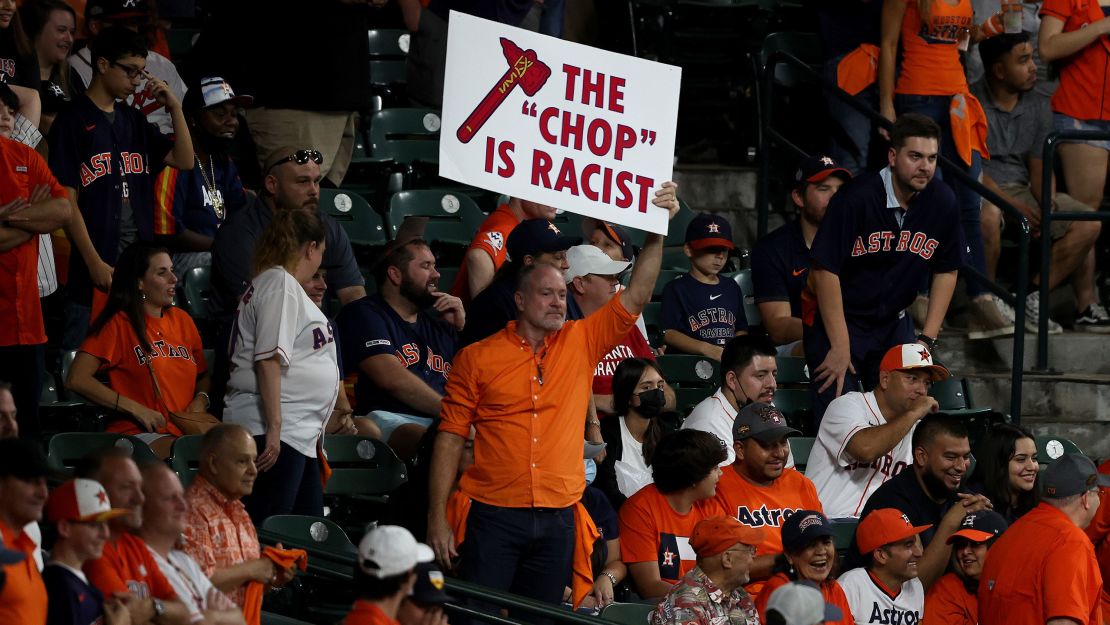 A fan holds a sign saying "the chop is racist" during the ninth inning in Game 1 of the World Series at Minute Maid Park on October 26, 2021, in Houston, Texas.