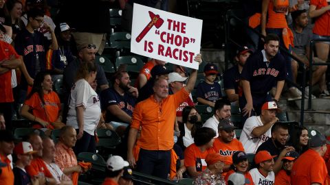 A fan holds a sign stating "the chop is racist" during the ninth inning in Game One of the 2021 World Series at Minute Maid Park in Houston.