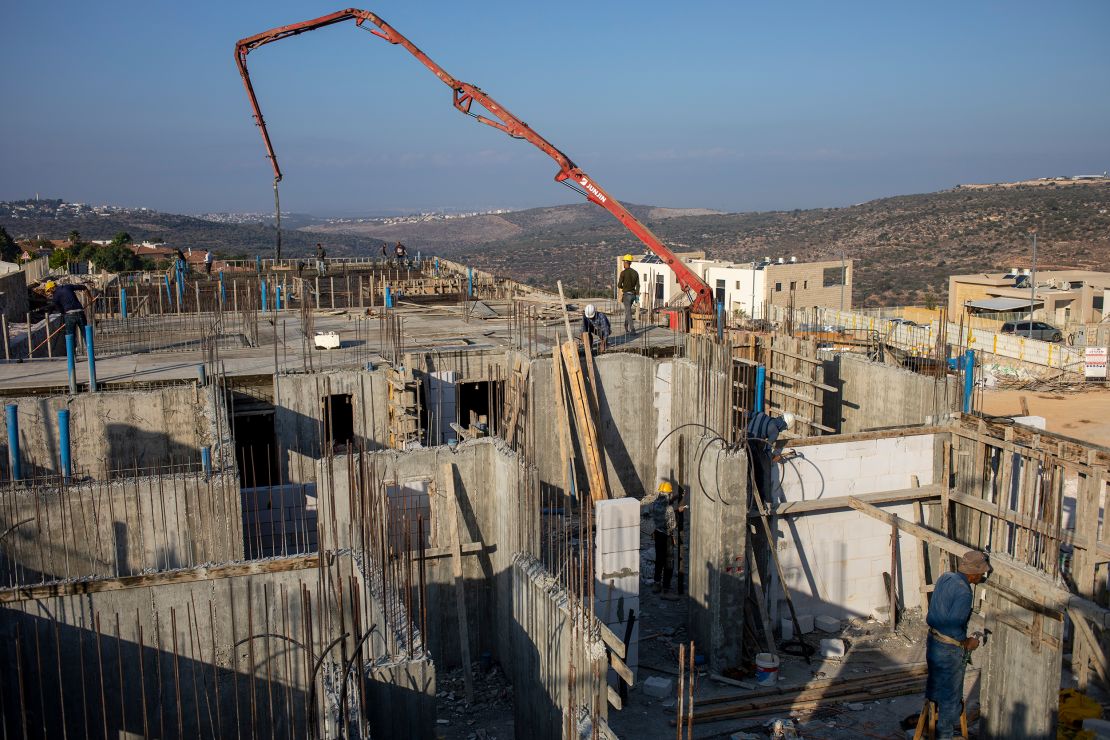 Palestinian laborers build new houses in the West Bank Jewish settlement of Bruchin on Monday, October 25, 2021. 