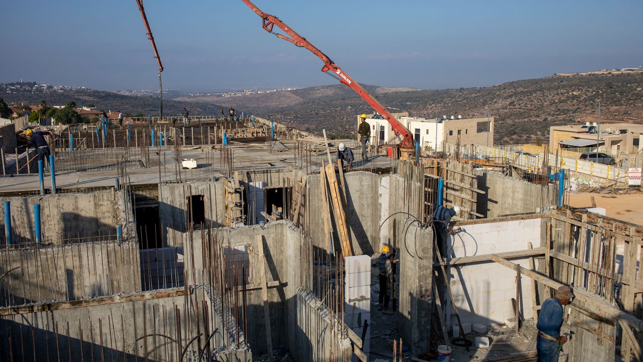 Palestinian laborers build new houses in the West Bank Jewish settlement of Bruchin on Monday, October 25, 2021.