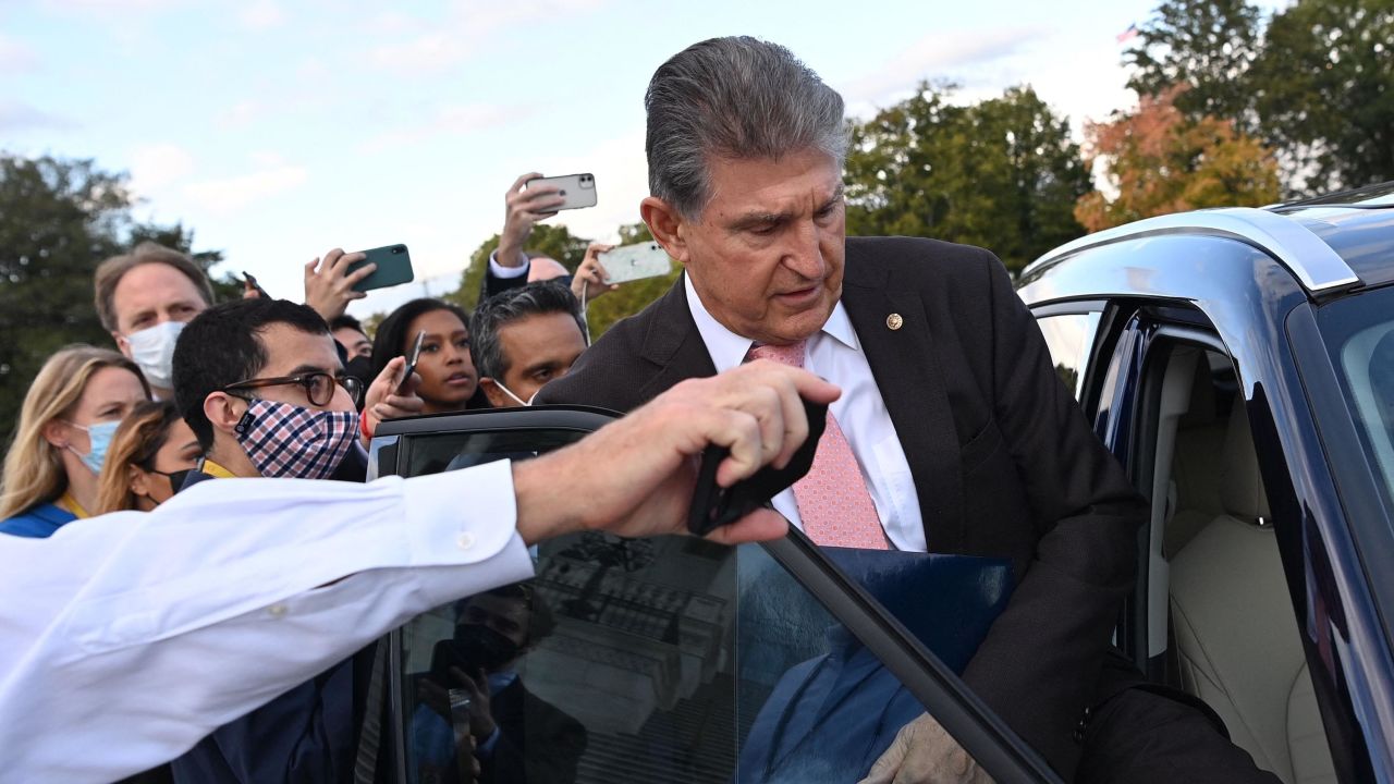 US Senator Joe Manchin (D-WV) gets into a car as members of the press ask question, after he left the US Capitol in Washington, DC, on October 28, 2021. 