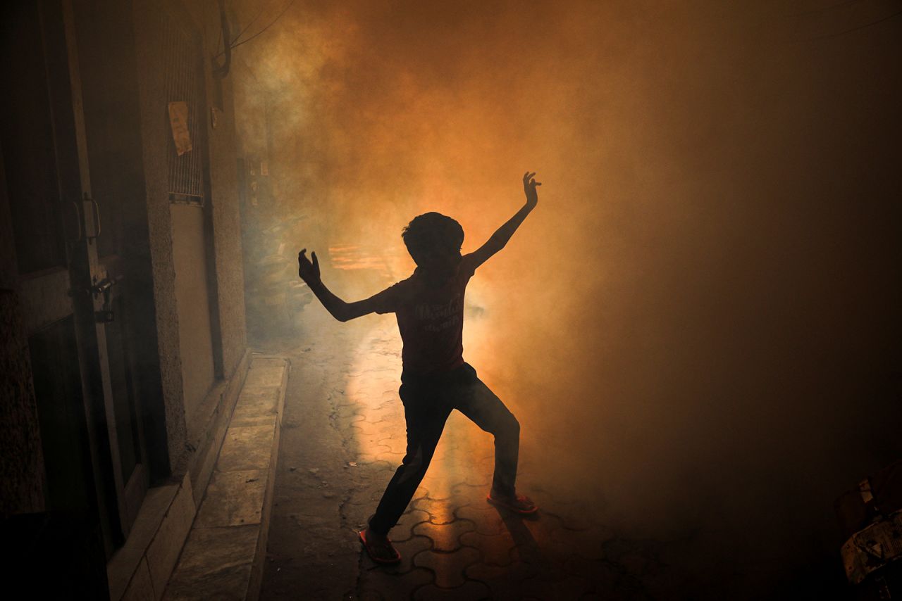 A child plays during a fumigation drive in New Delhi on Wednesday, October 27. The Indian city is trying to combat surging cases of dengue.