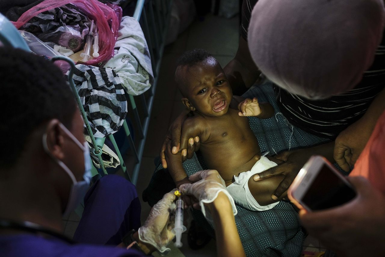 Someone uses a cell phone for a flashlight as a baby is given an IV at a hospital in Port-au-Prince, Haiti, on Tuesday, October 25. Haiti has been dealing with a <a href="https://www.cnn.com/2021/10/26/world/haiti-fuel-hospital-intl-latam/index.html" target="_blank">nationwide fuel shortage</a> that has severely impacted some of its hospitals.