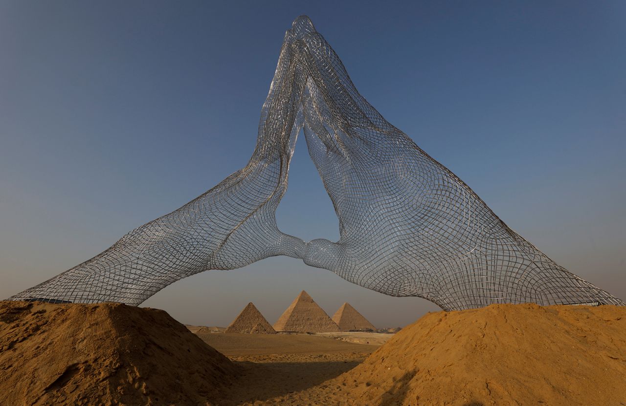The sculpture "Together," created by Lorenzo Quinn, is seen in front of the Great Pyramids of Giza, on the outskirts of Cairo, on Saturday, October 23. Quinn, an Italian sculptor, is the son of late actor Anthony Quinn. <a href="http://www.cnn.com/2021/10/22/world/gallery/photos-this-week-october-14-october-21/index.html" target="_blank">See last week in 37 photos</a>