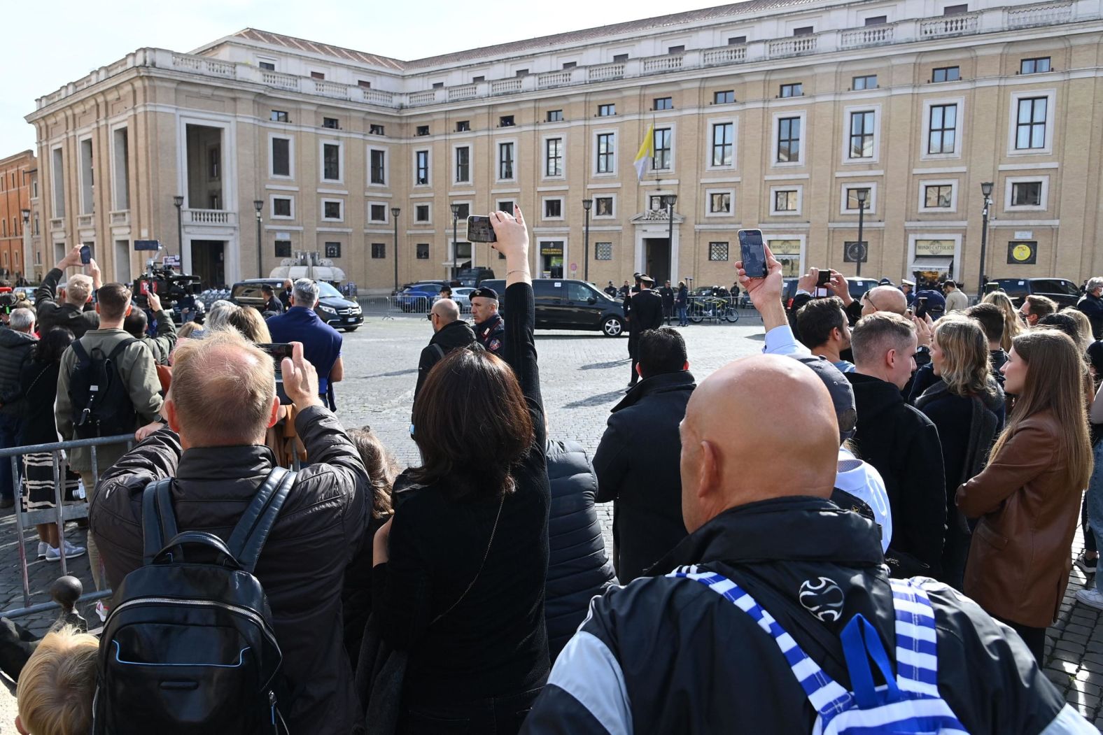 People watch Biden's motorcade in Rome on Friday.
