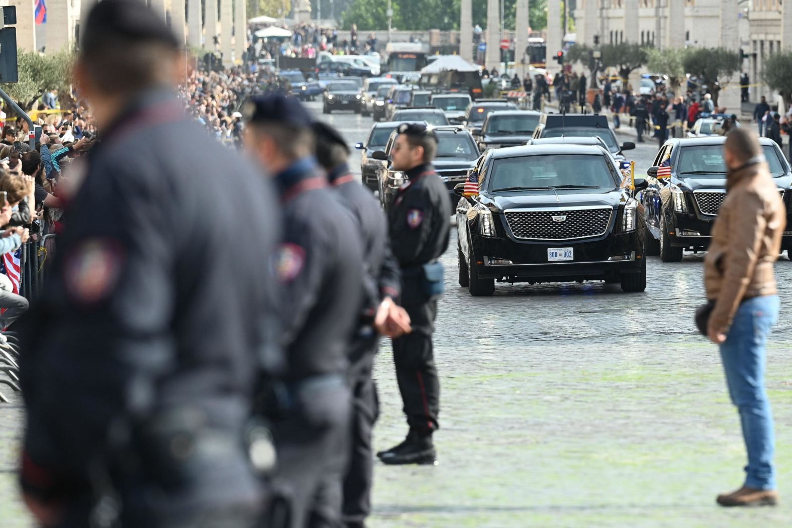 Police officers stand as Biden's motorcade drives by Friday en route to the Vatican.