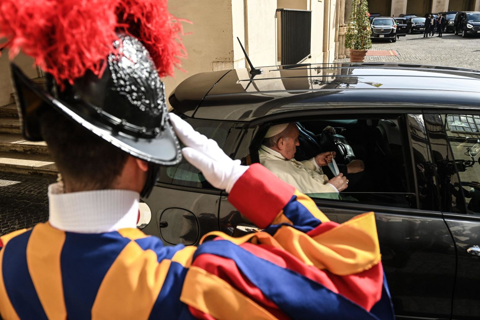Pope Francis leaves in a car following his private audience with Biden.