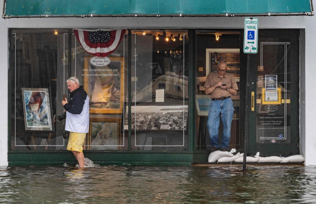 A man walks past an art gallery through floodwaters in downtown Annapolis, Maryland, on Friday.