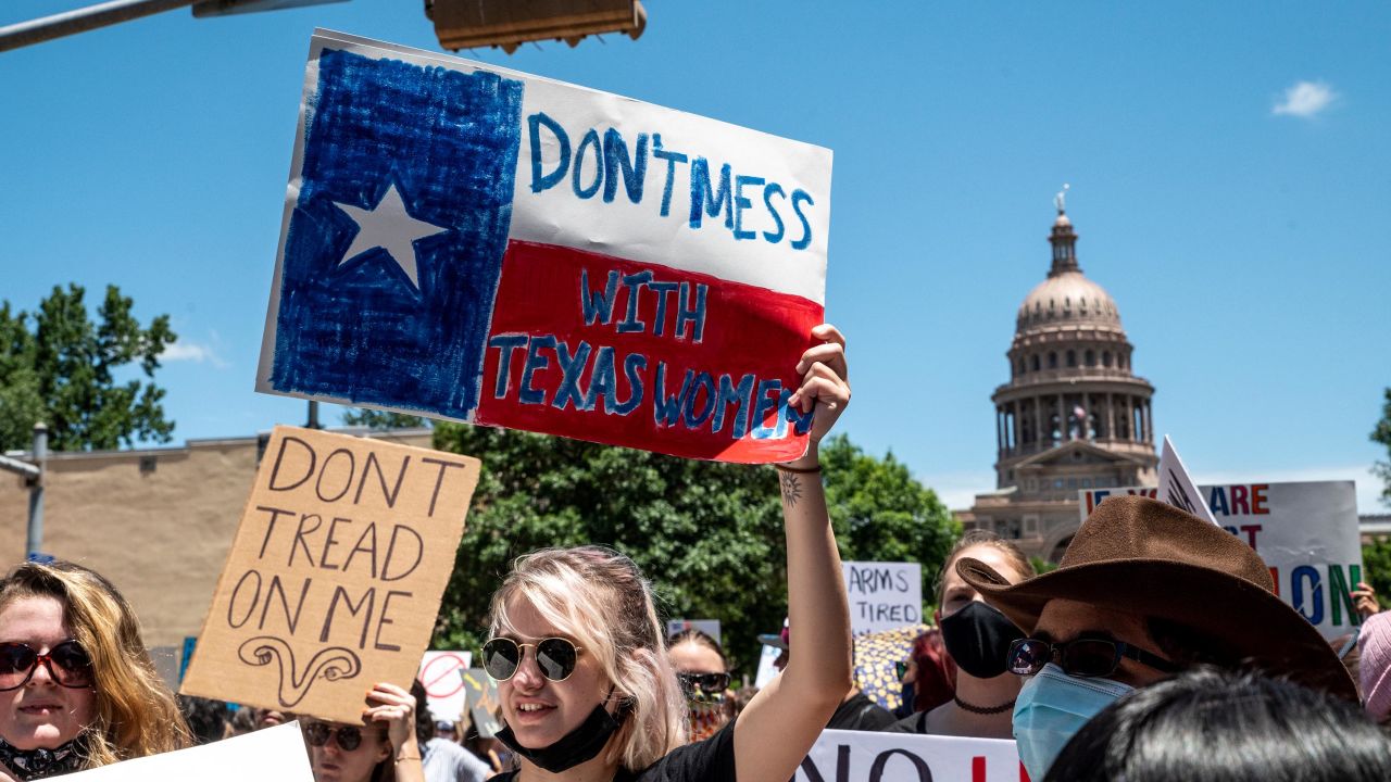 Protesters hold up signs as they march down Congress Ave at a protest outside the Texas state capitol on May 29, 2021 in Austin, Texas.
