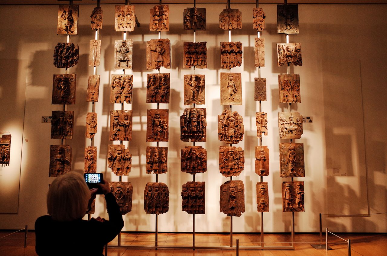 A visitor takes photos of the contentious Benin plaques exhibit at the British Museum in London.