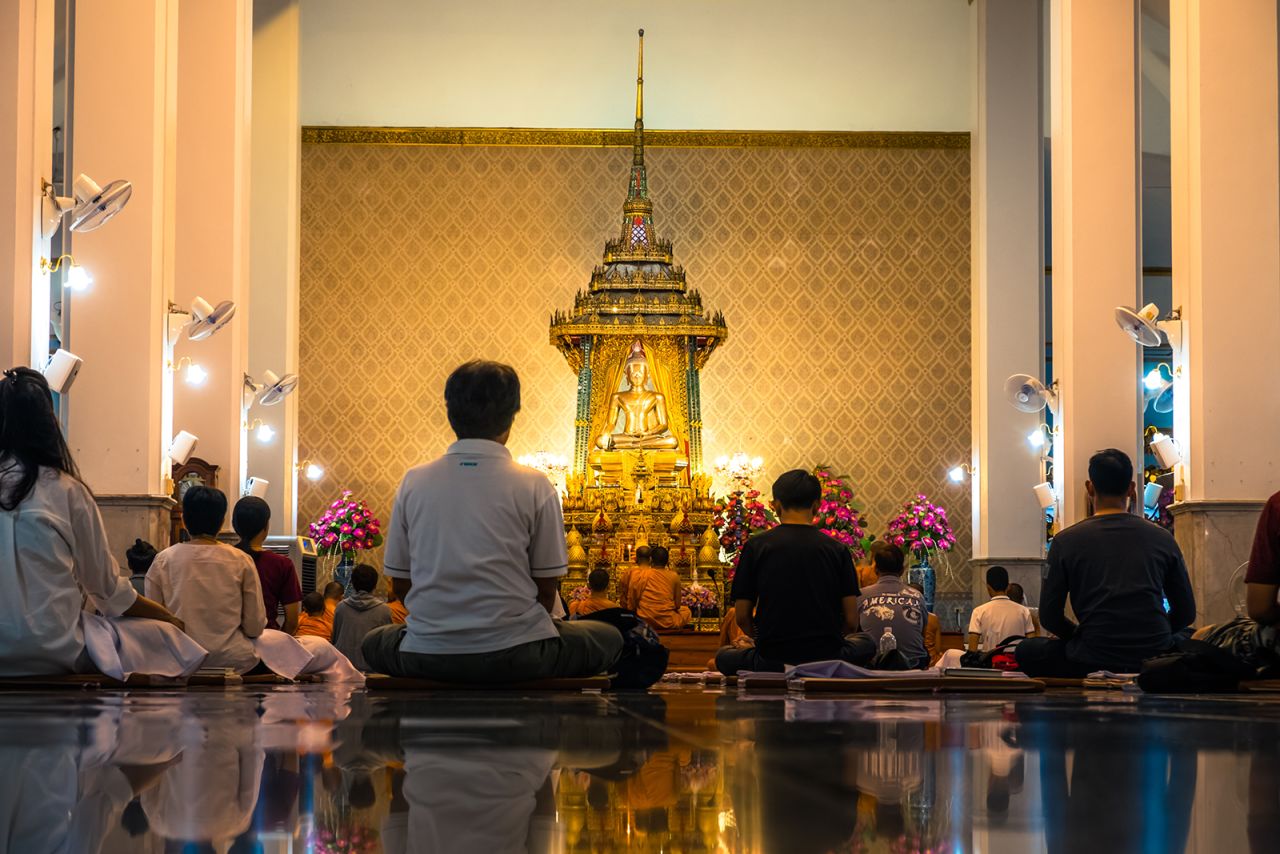 People meditate in a central Bangkok temple. 