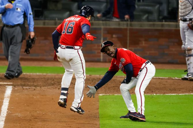 Travis d'Arnaud of the Braves is greeted by third base coach Ron Washington after hitting <a href="index.php?page=&url=https%3A%2F%2Fwww.cnn.com%2Fsport%2Flive-news%2Fworld-series-2021-braves-astros-game-3%2Fh_4e9813f01622f40c71cde02aaff14f17" target="_blank">a solo home run</a> in the eighth inning.