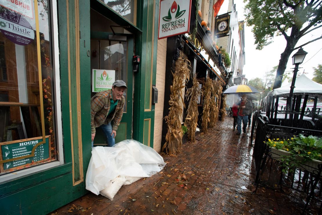Edward Guerrero checks the height of floodwaters outside of his ice cream shop as the Potomac River overflows its banks, in the historic Old Town section of Alexandria, Virginia, on October 29, 2021. 