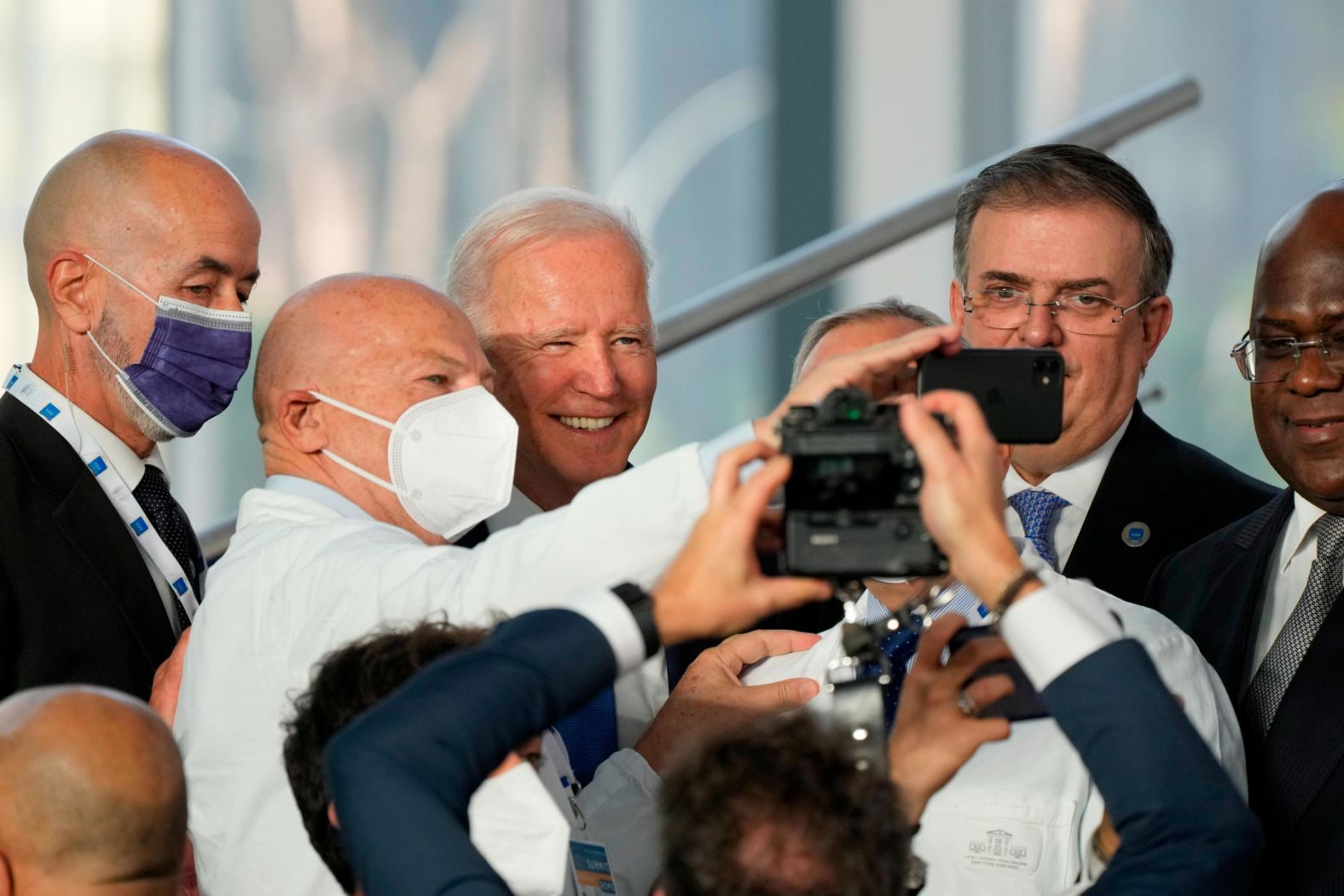 Biden poses for a selfie with medical personnel and other world leaders during Saturday's group photo shoot.