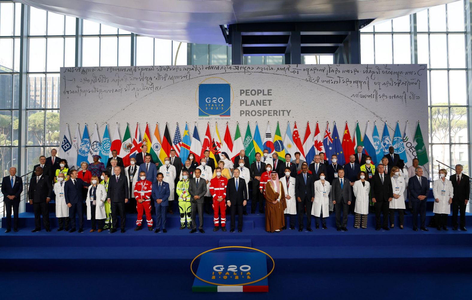 World leaders are joined by medical workers as they gather for an official photo at the G20 summit on Saturday. Biden is on the far left.