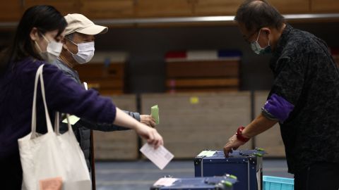 People cast their ballots for Japan's general election at a polling station in Tokyo on October 31.